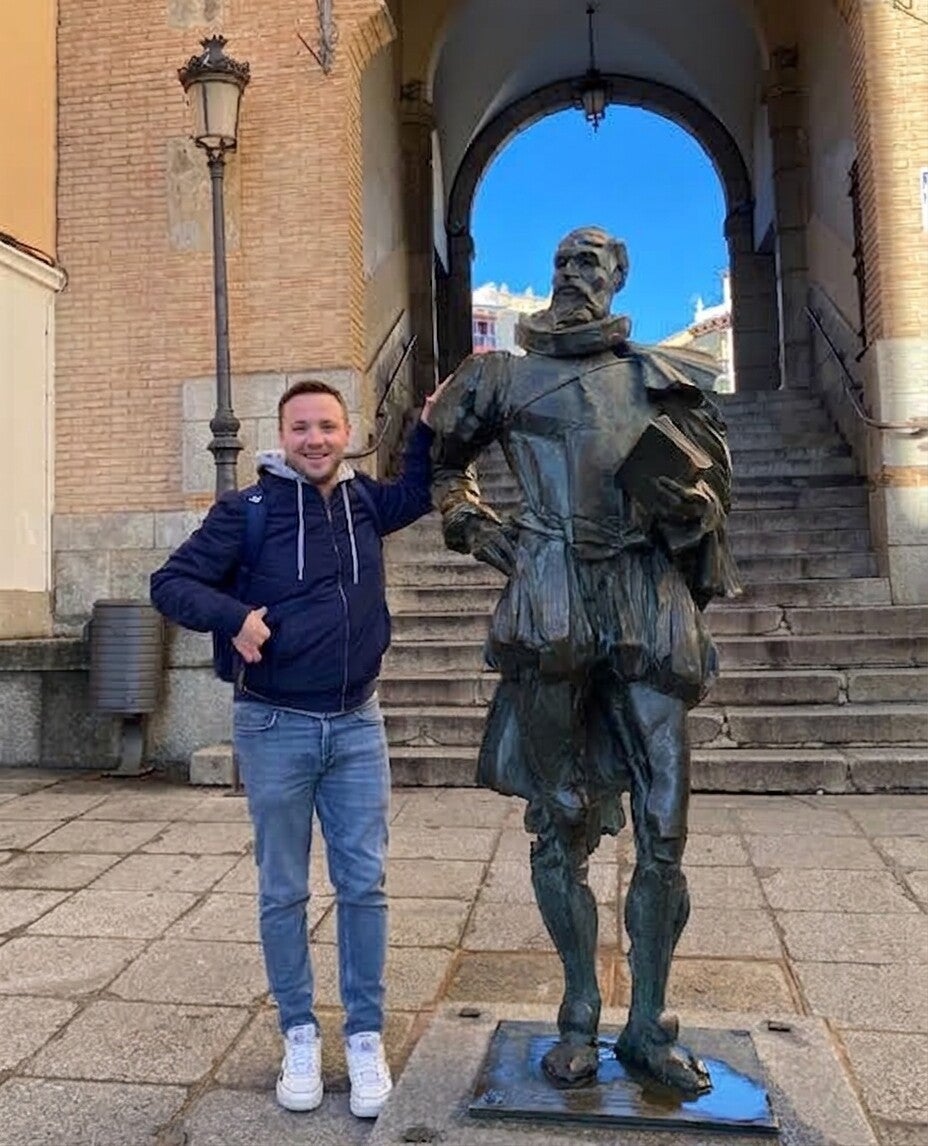 Professeur d'espagnol devant la statue de Miguel de Cervantes à Toledo