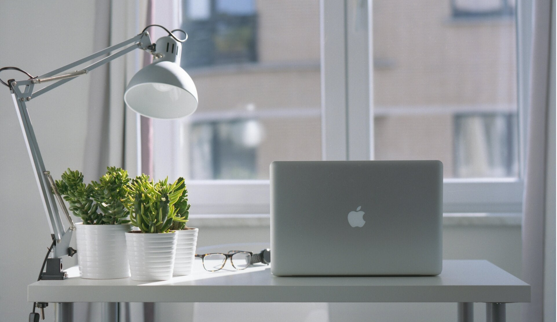 Bureau met een open laptop en een paar groene planten