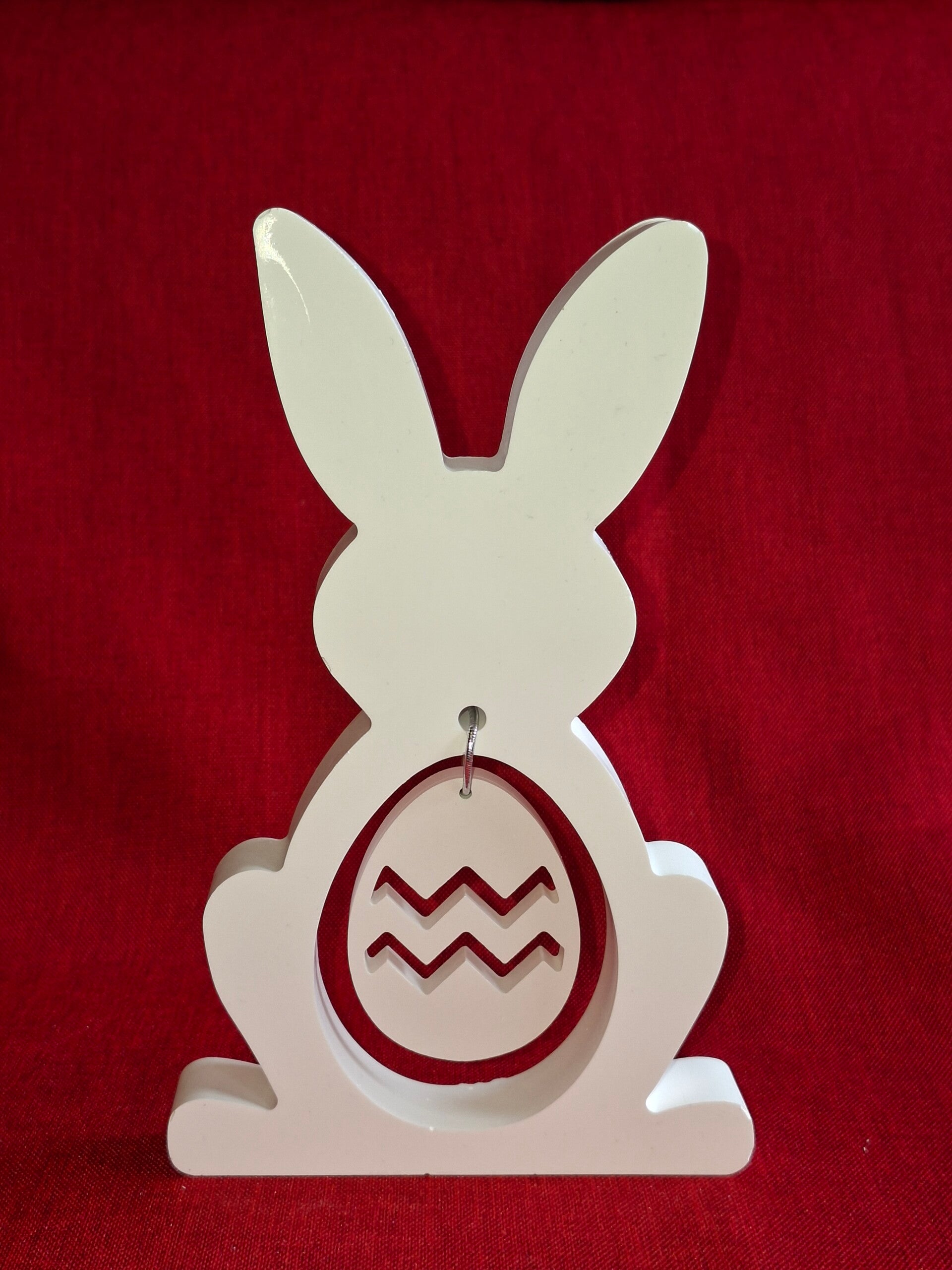 Stehender Hase mit hängendem Ei