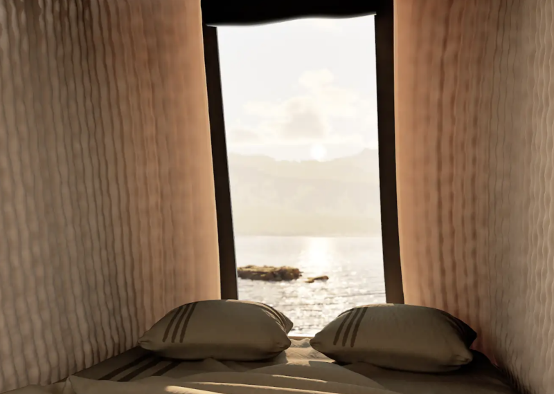 Lit confortable avec vue sur un lac et des montagnes depuis une chambre lumineuse avec livre ouvert, ambiance cosy et nature.