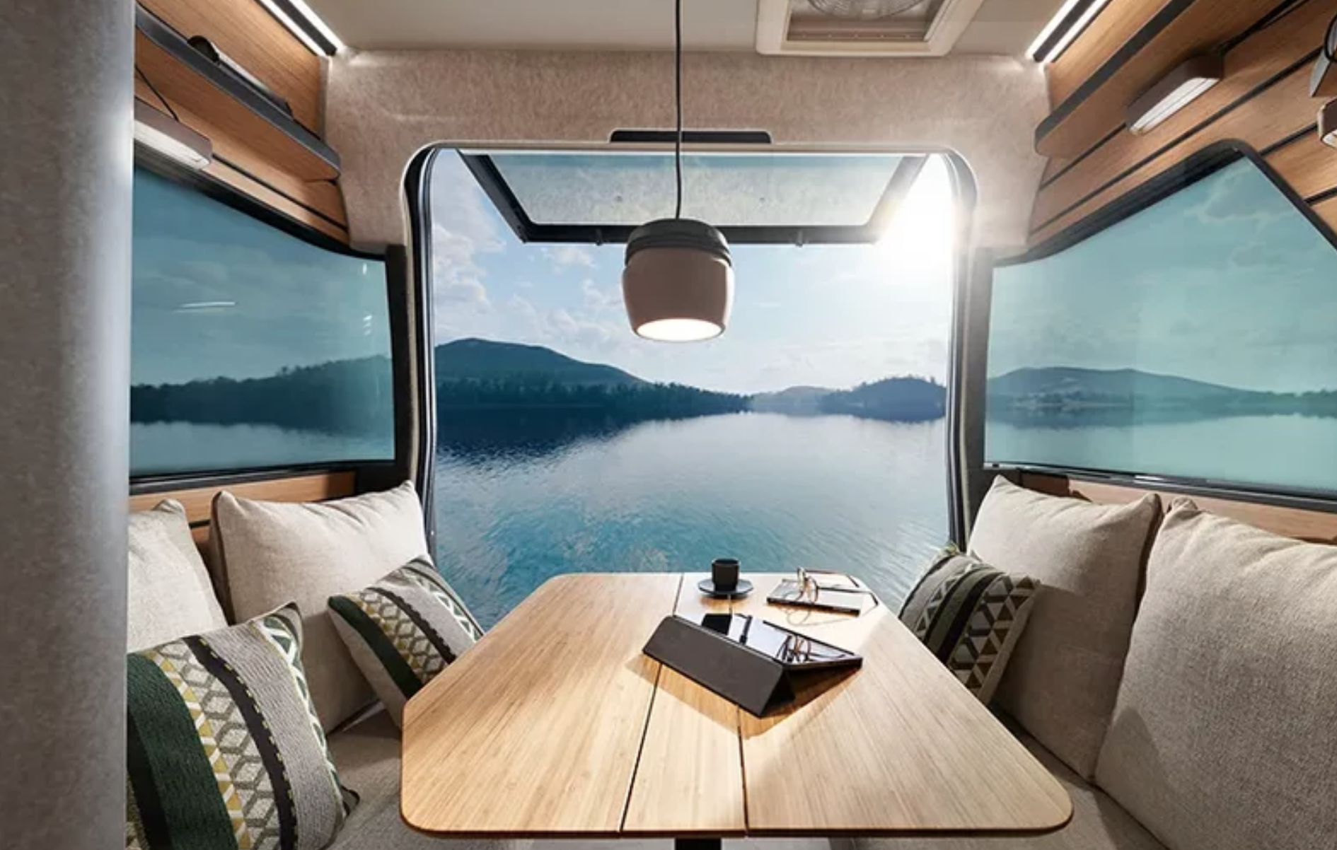 Cuisine et coin repas du Venture S avec kitchenette moderne, banquette et grandes fenêtres avec vue sur la mer