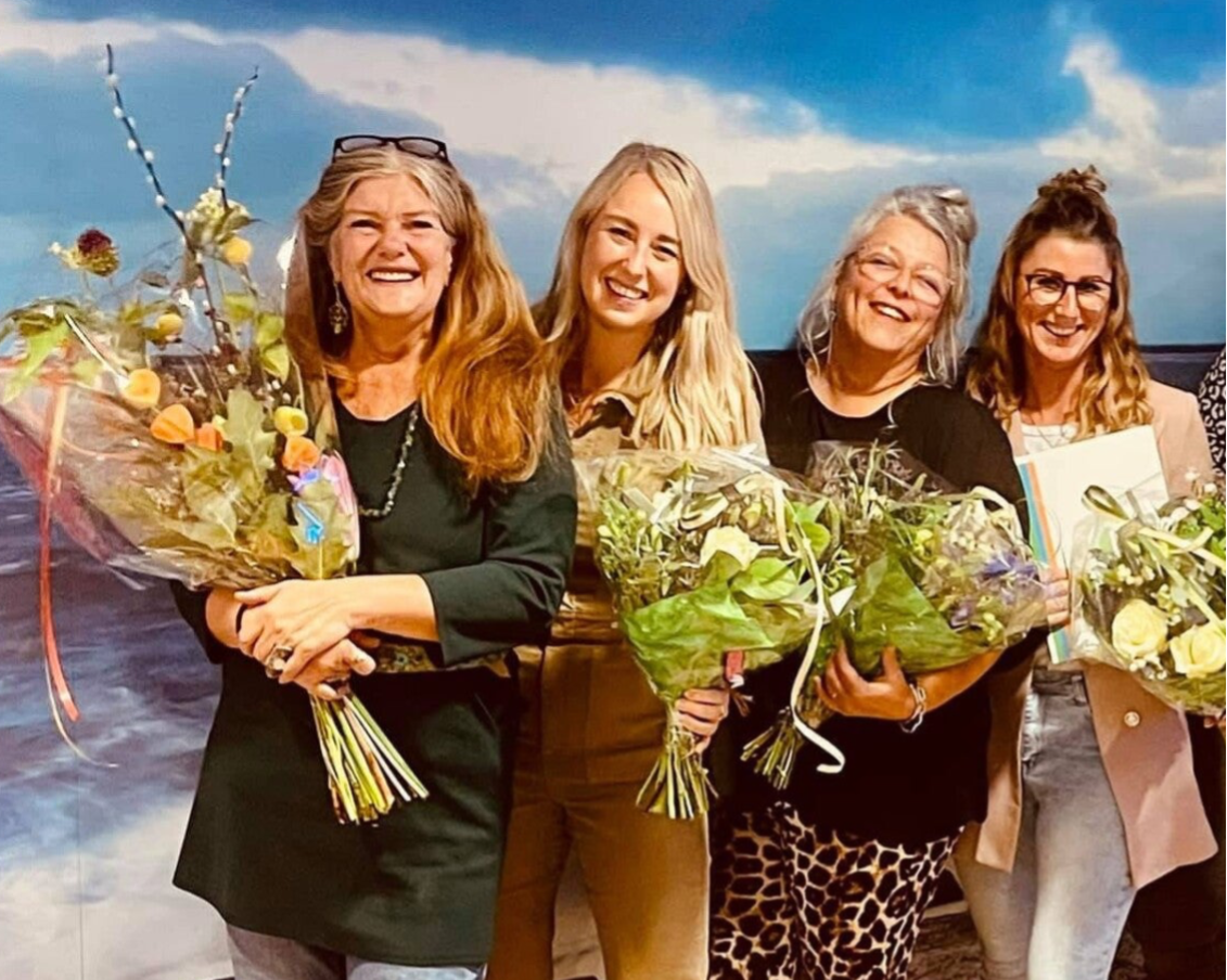 Marianne Pheil met deelnemers van een training, met bloemen na de afsluiting