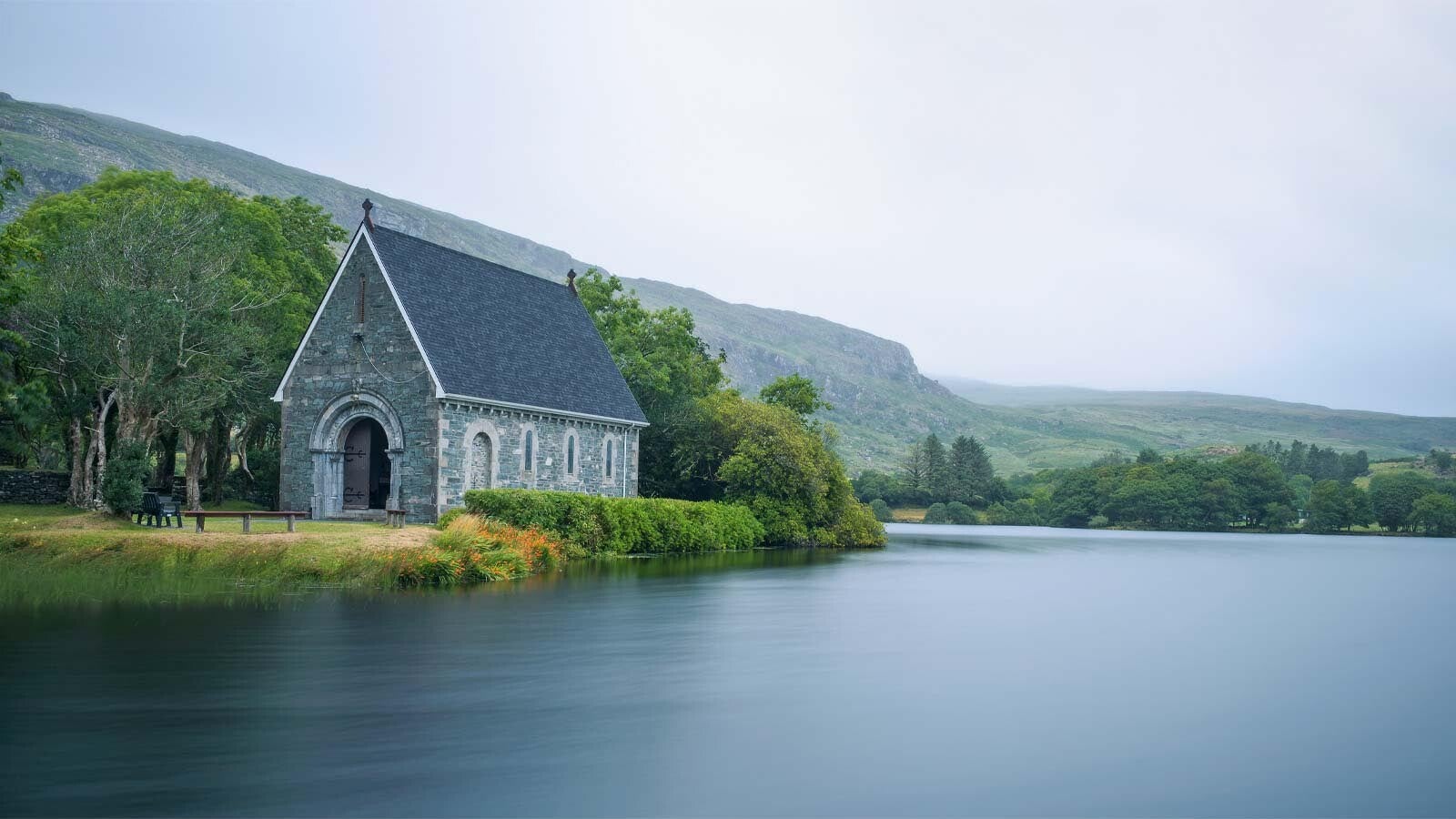 St. Finbarre's Oratory, sitting on an island in a lake. Mountains in the background. 