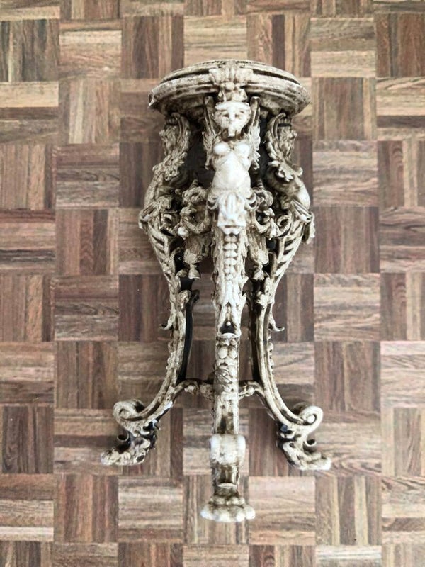 Miniatuur plantenstandaard met gedetailleerde sculpturen