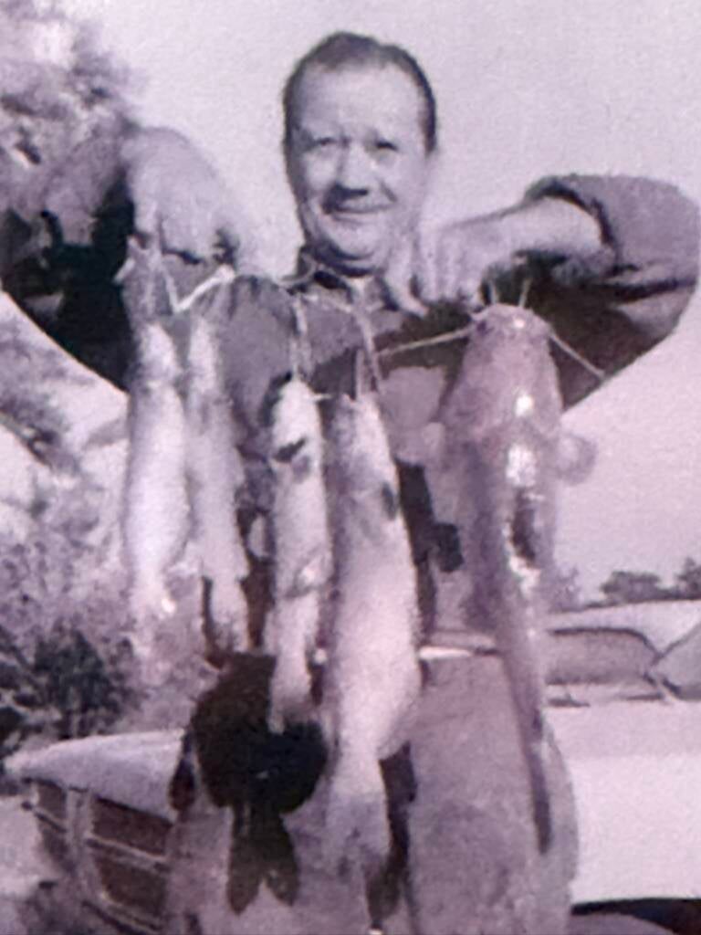 Dad holding up a stringer of catfish.