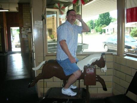 Grown up man drying on a mechanical horse. 