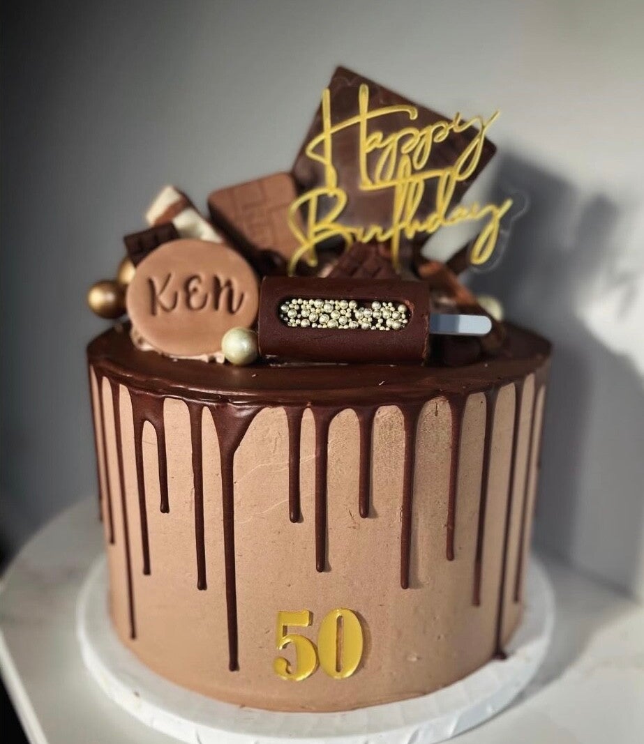 A 50th birthday cake in chocolate swiss meringue buttercream and chocolate drip.