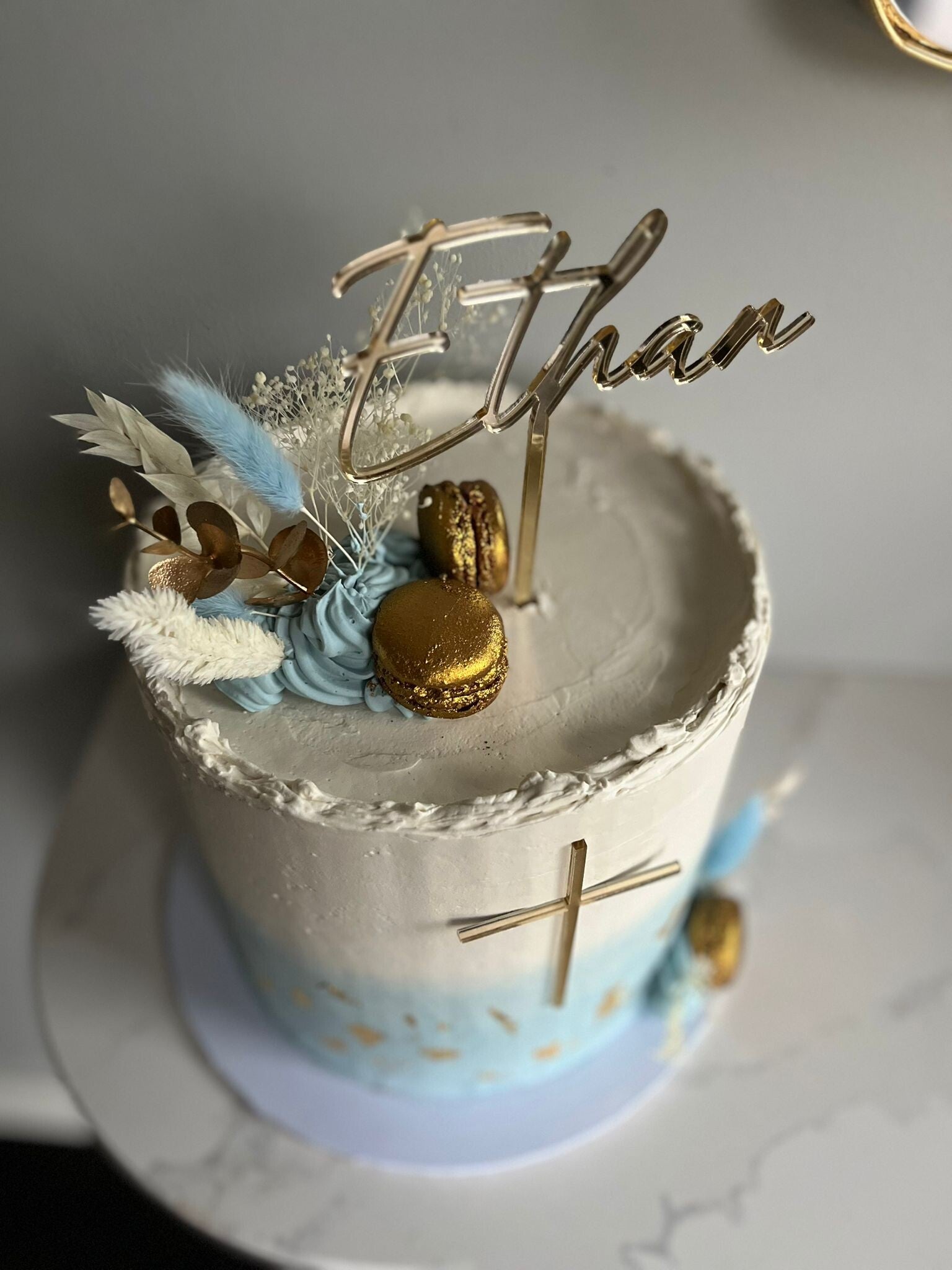 A cake for celebrating communion in cream and blue swiss meringue buttercream