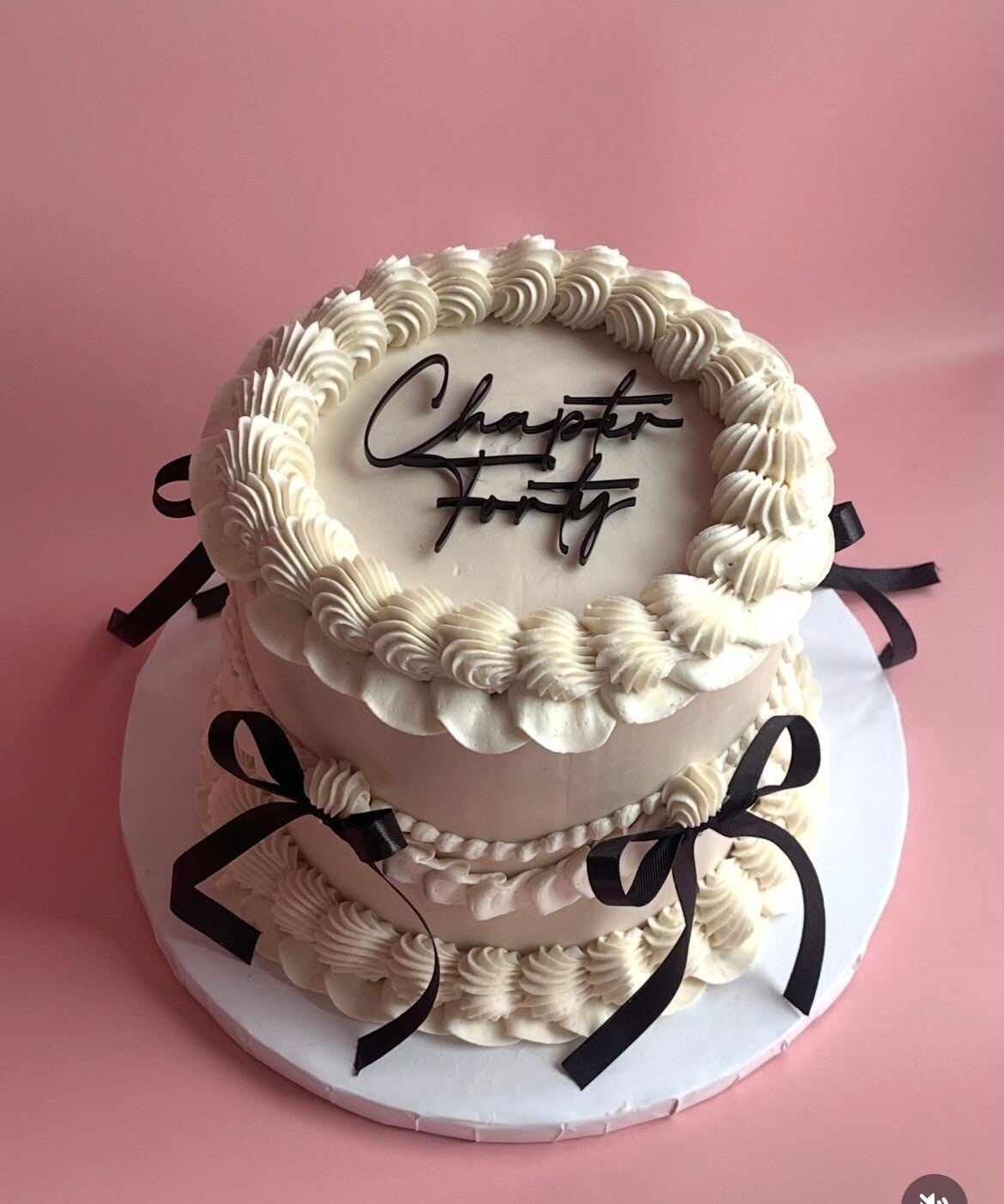 Tall celebration cake covered in smooth swiss meringue buttercream in bright orange, pink, red and gold colours, with Happy Birthday topper. 