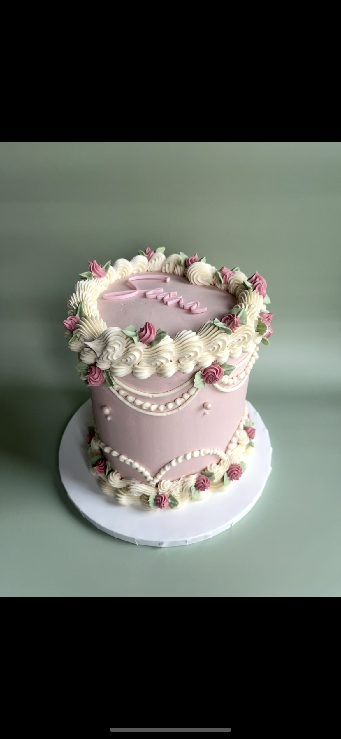 Vintage styled occasion cake with large swiss meringue buttercream icing and small blue, pink and green piped flowers