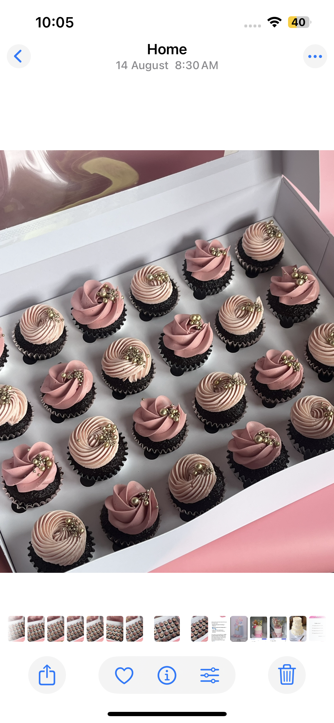 Tall anniversary cake in cream and gold with iced stencilled pattern and large flower topper