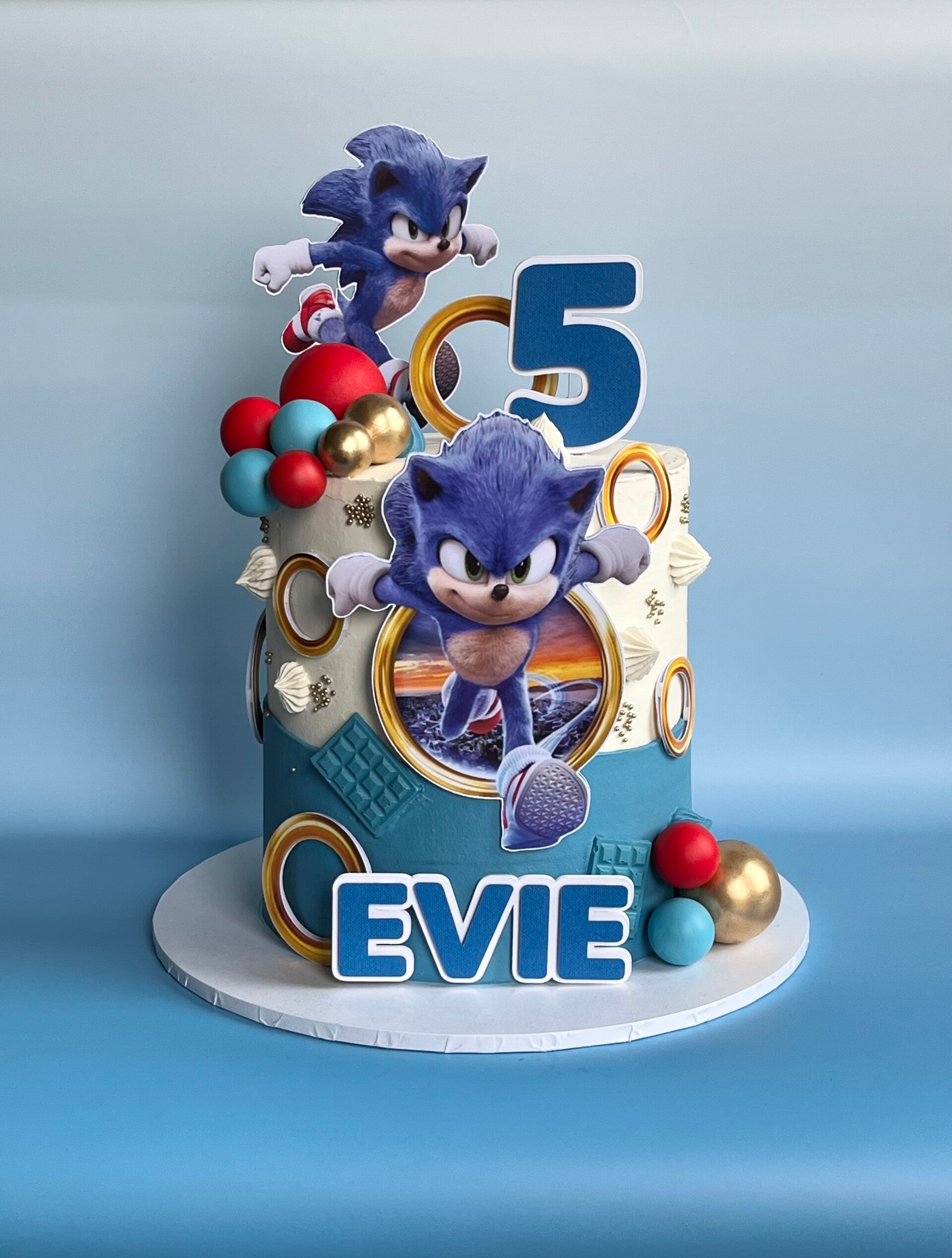 Smaller sized celebration cake iced in swiss meringue buttercream with cream pink and blue colours