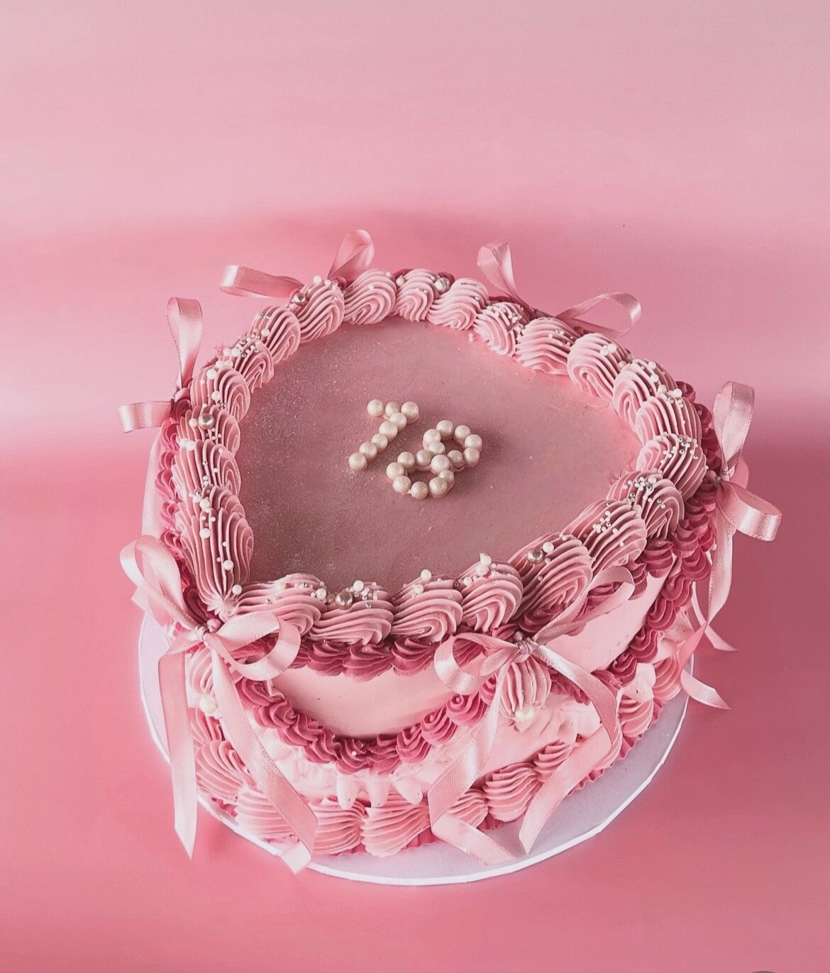 Round vintage cake with large piped buttercream icing and ribbons.