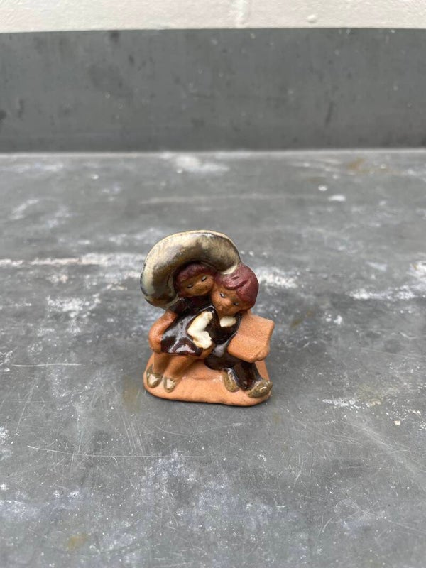 Schattig letterbak miniatuurtje, zittend met boek