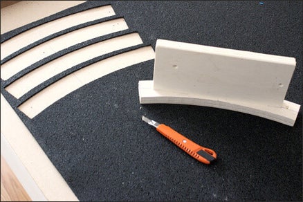 Op de foto het uitsnijden van het rubbergranulaat als dempend materiaal voor de onder de modelrails en modeltreinen met behulp van mallen