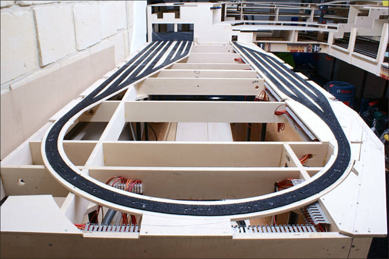 Foto van de segmenten F en G van de modelbaan. De segmentenframes zijn opgesteld en de ringleiding is aangelegd. De onderleggers voor de modelrails van de eventuele uitbreiding van het schaduwstation zijn op het frame gemonteerd en het akoestische demping