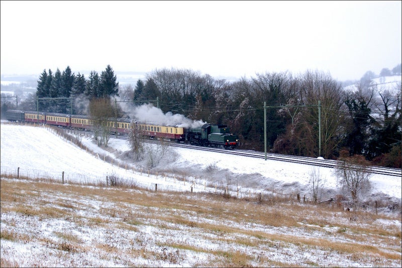 linksrijdende ZLSM-trein met stoomlok rijdt richting Valkenburg door een besneeuwd landschap ter hoogte van de Schaelsberg