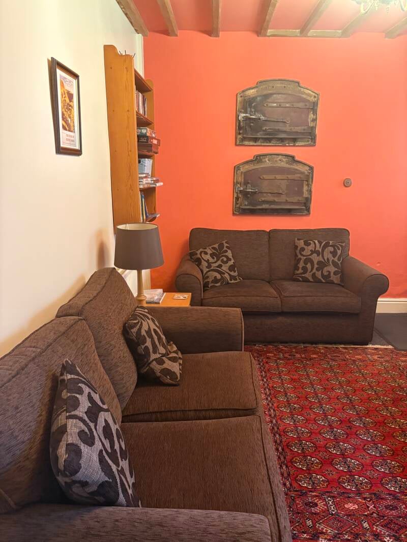 A comfortable lounge with two sofas and original bakery oven doors
