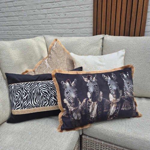 Set van 4 kussens in licht beige/bruin en zwart tinten, met verschillende texturen waarvan 1 kussen een door ai ontworpen print van 4 zebra's in kleding