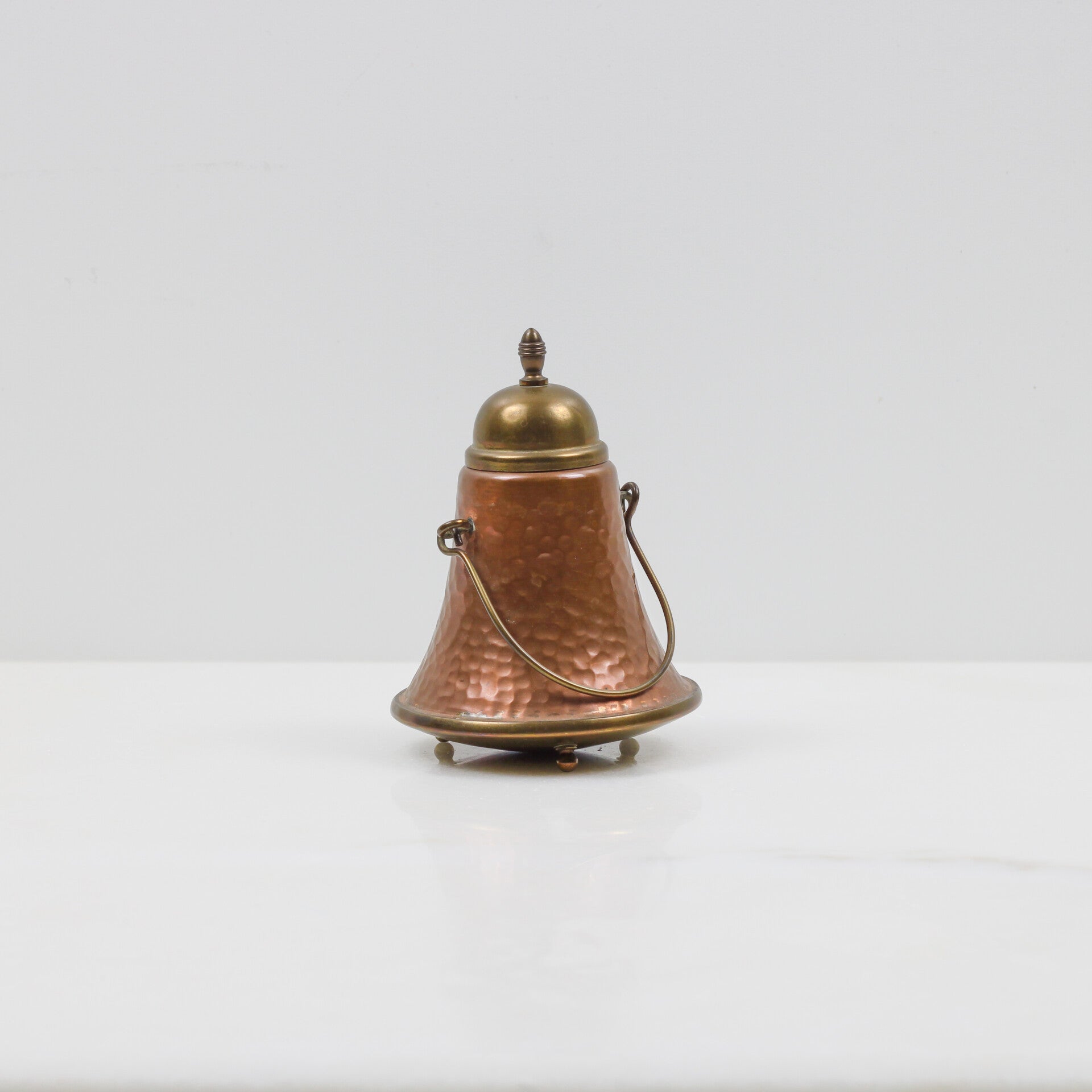 Miniatuur doofpotje, uitgevoerd in gehamerd rood- en geelkoper (messing)