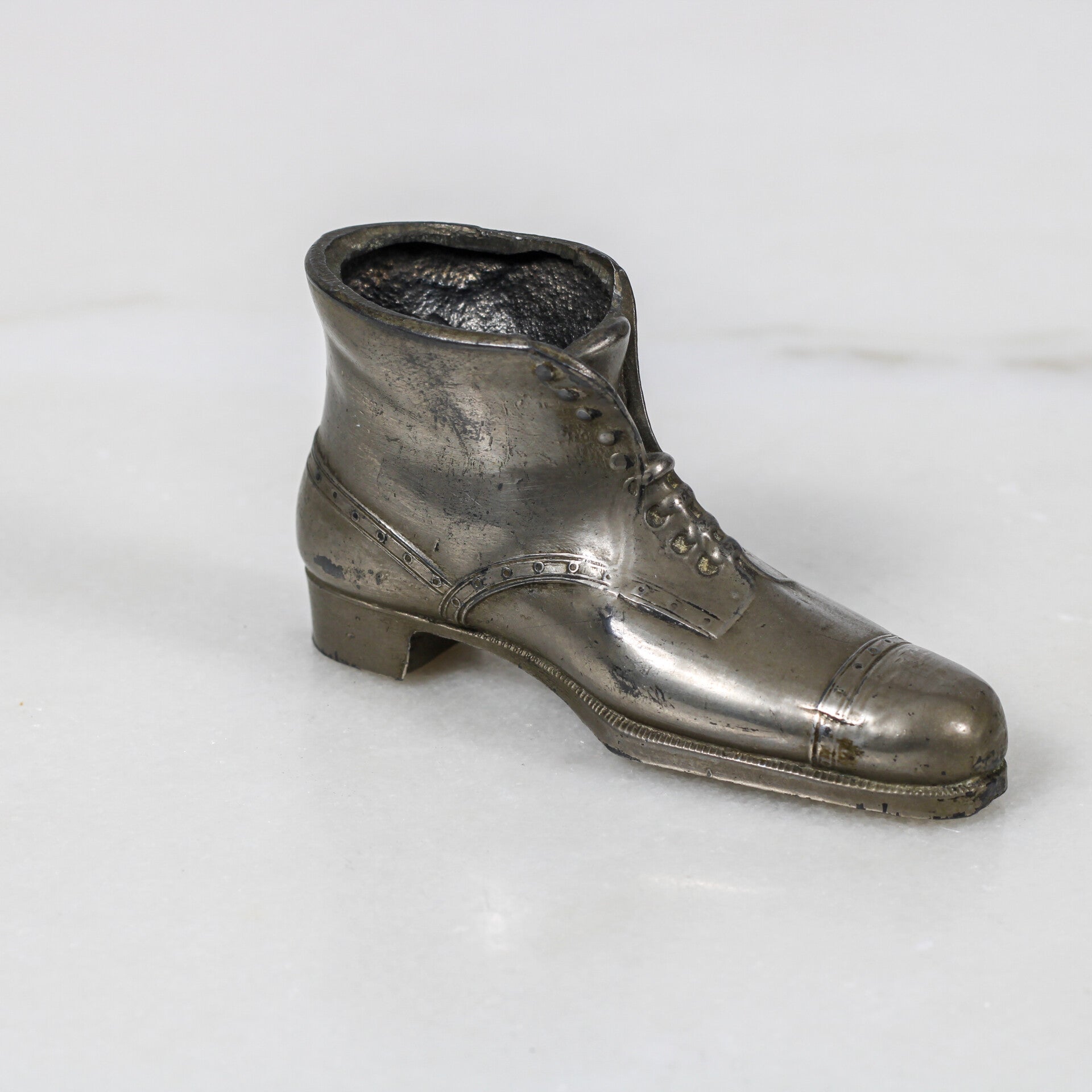 Miniatuur tinnen speldenkussen of snuisterijhouder in de vorm van een laars