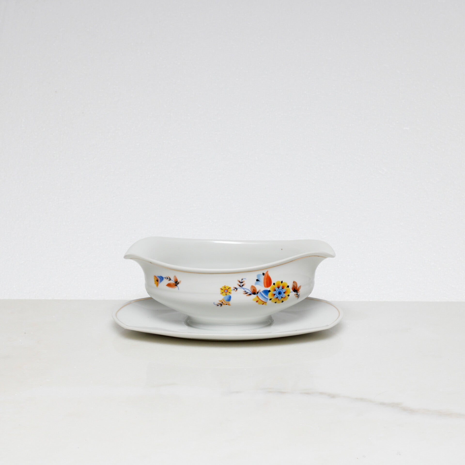 Mosa Maastricht ovale sauskom met een geel-blauw bloemmotief en een goudkleurige rand