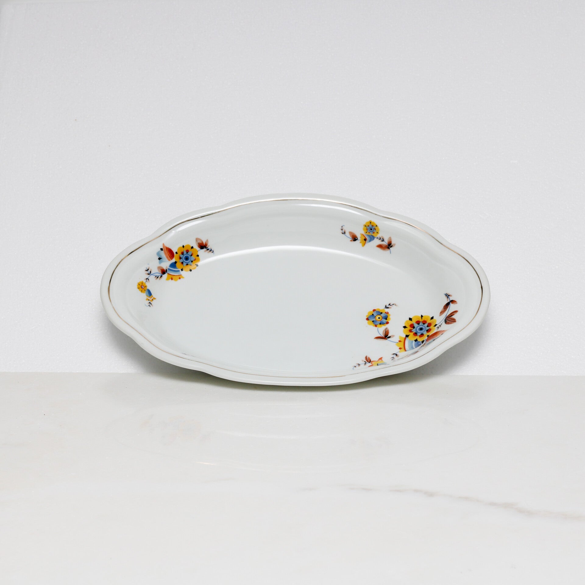 Mosa Maastricht ovale serveerschaal met een geel-blauw bloemmotief en een goudkleurige rand