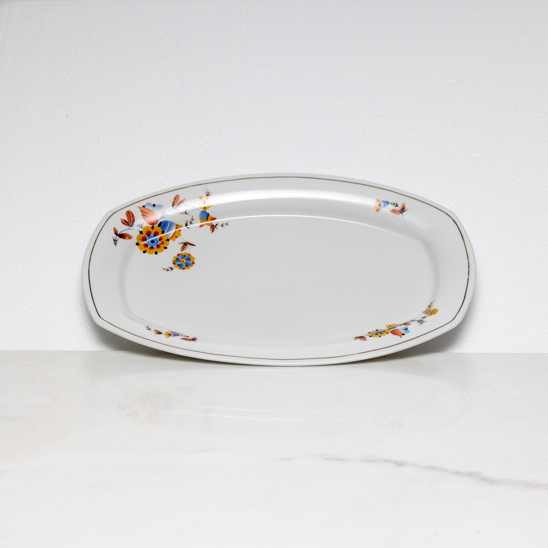 Mosa Maastricht ovale serveerschaal met een geel-blauw bloemmotief en een goudkleurige rand