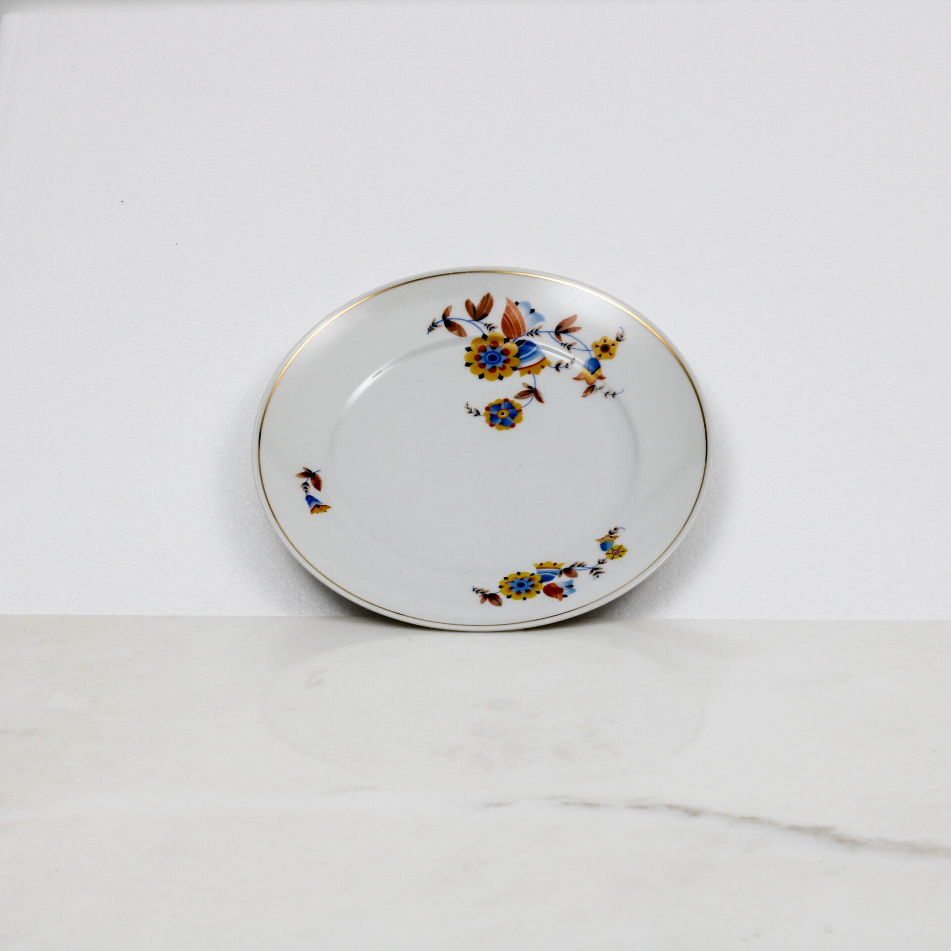 Mosa Maastricht dinerbord met een geel-blauw bloemmotief en een goudkleurige rand