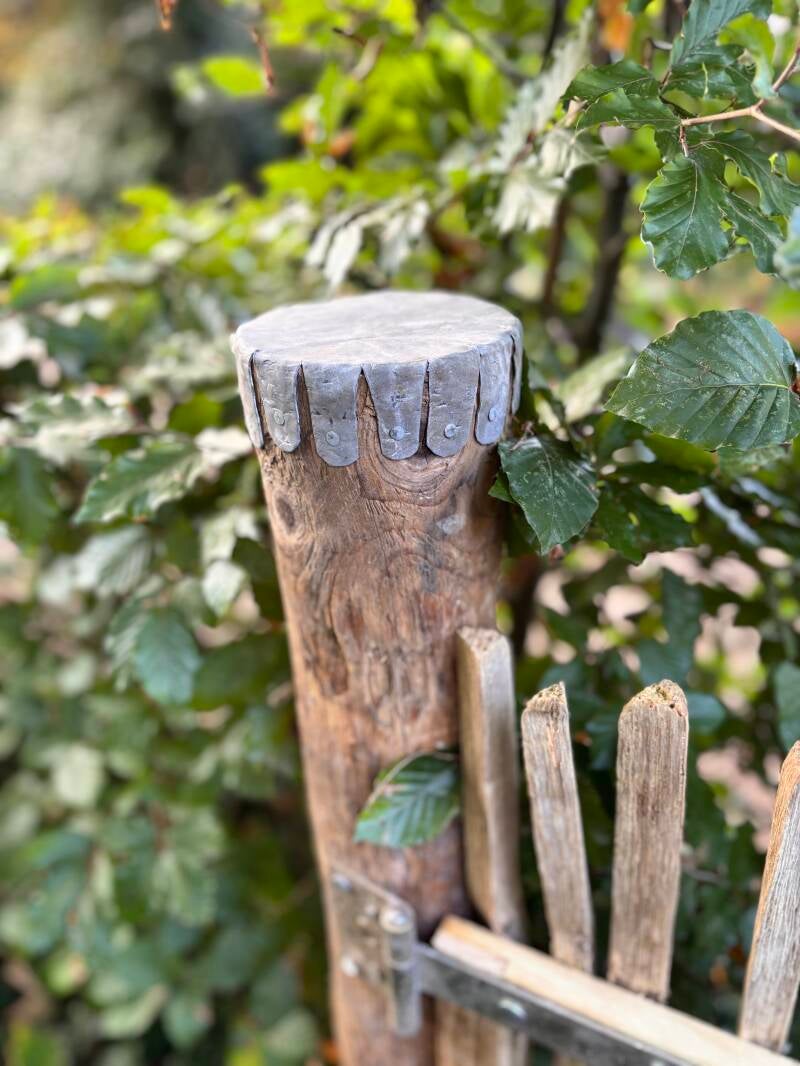 Loden afdekking op paal van houten hek