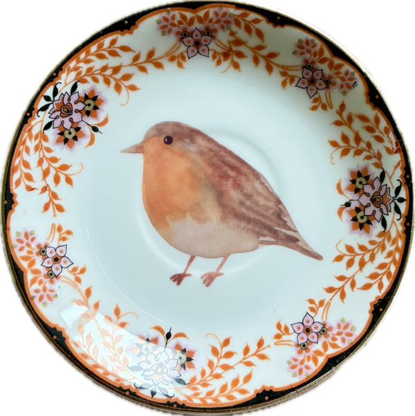 Roodborstje op schotel met decoratieve rand