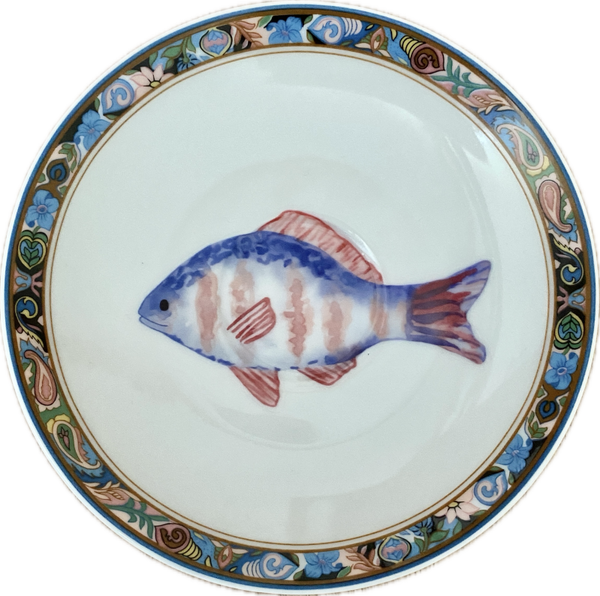 Blauwe vis op schotel met decoratieve rand