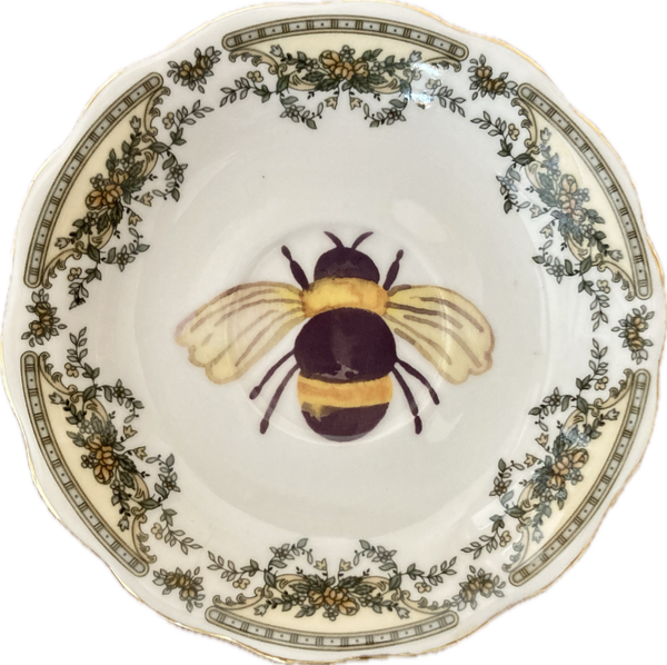 Bij op schotel met decoratieve rand