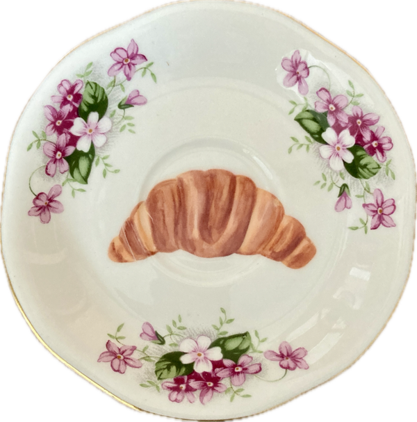 Croissantje op schoteltje met bloemen