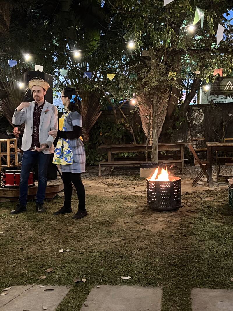 Kleines Lagefeuer mit Mann mit Strohhut und Frau mit Zöpfen