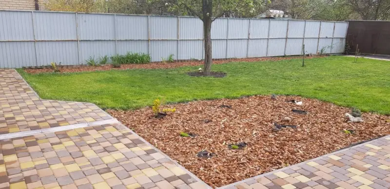 Boomschors als bodembedekking rond een boom en in een tuinperk