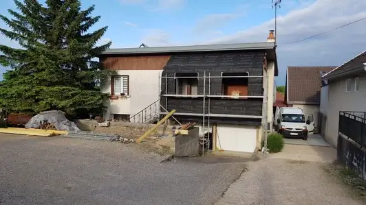 Extension de maison en cours de chantier à Vosne-Romanée avec ossature, pare-pluie et échafaudage en façade.