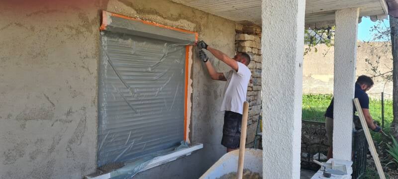 Finition de façade avec pierre apparente et enduit rénové à Saint-Bernard.