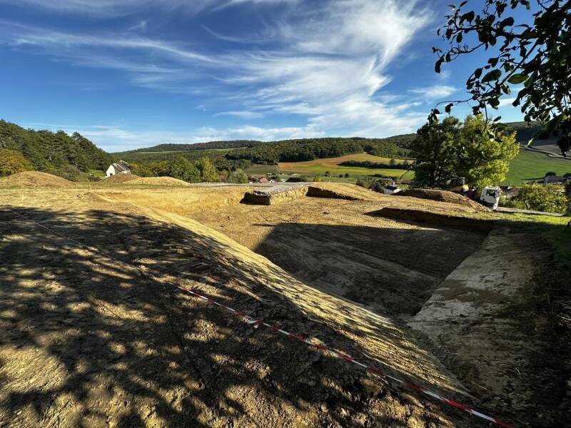 Terrassement de terrain en pente avec pelle à chenilles pour un projet de construction à Clémencey