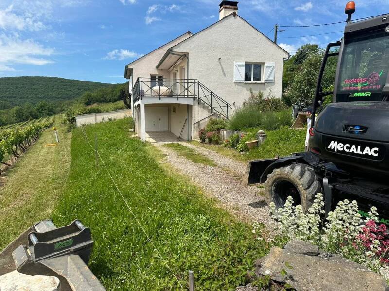 Terrassement d’un accès de maison avec engin de chantier en bord de vignes