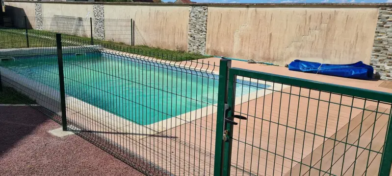 Clôture rigide terminée avec portillon autour d’une piscine familiale à Saint-Bernard.