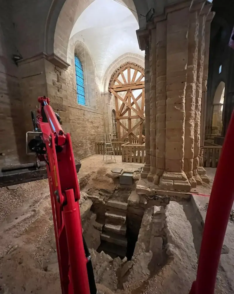 Dégagement des fondations anciennes au pied d’un pilier dans une église historique.