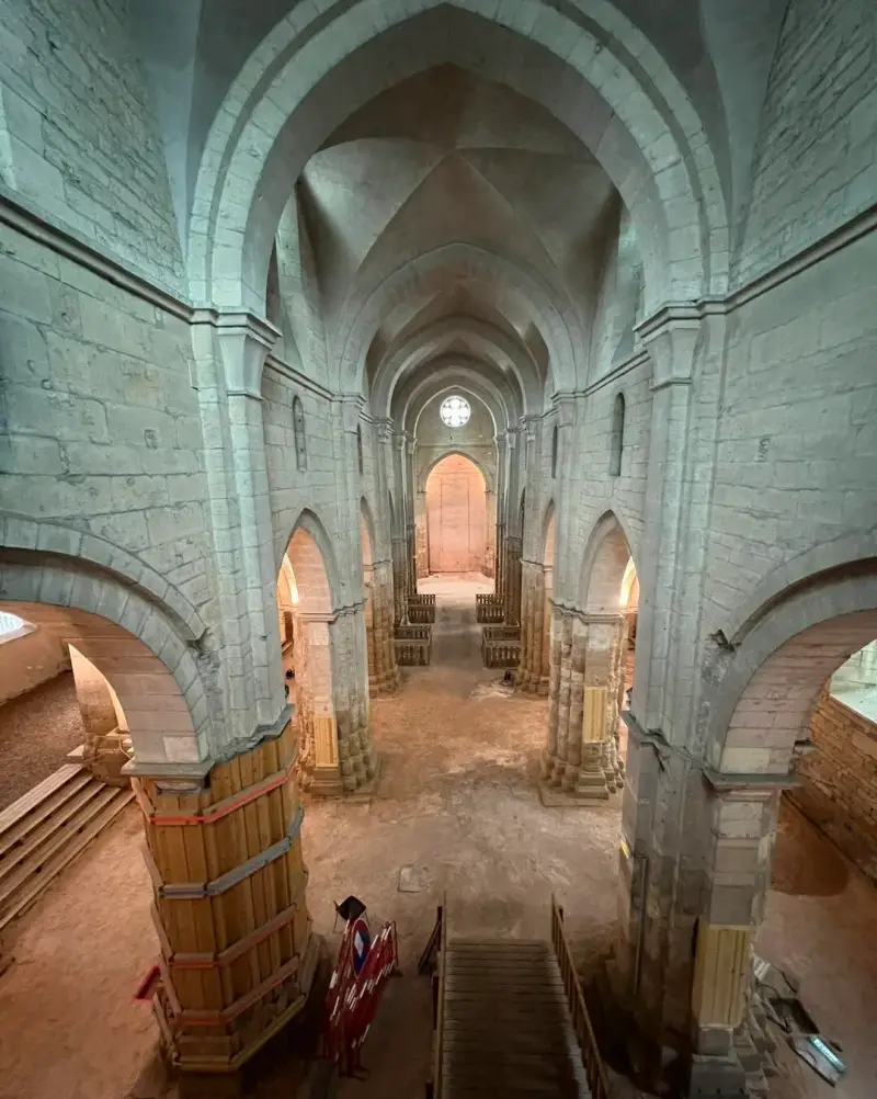 Vue générale de la nef d’une église en cours de restauration avec protections en bois.