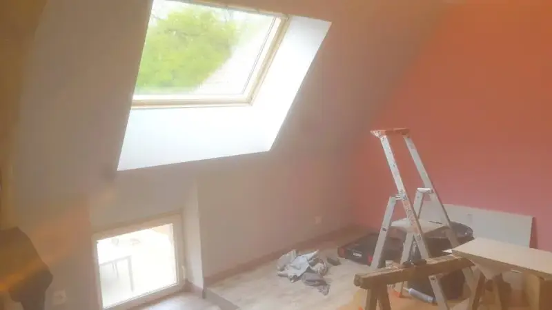 Finitions d’une chambre sous combles à Demigny avec fenêtre de toit, peinture et parquet.