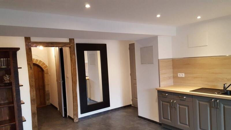 Pièce rénovée à Corgoloin avec création d'un espace cuisine, murs clairs, sol foncé et finitions modernes.