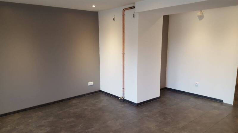 Angle de pièce rénovée à Corgoloin avec mur bicolore, sol moderne et finitions intérieures soignées.
