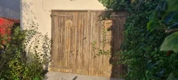 Ancienne porte de garage en bois avant remplacement sur une maison à Saint-Bernard.