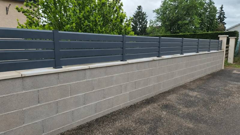 Avant travaux à Saint-Bernard : muret de clôture en parpaings avec clôture aluminium avant application de l'enduit de finition.