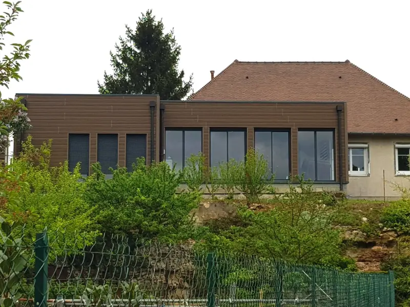 Extension de maison terminée à Meursault avec bardage bois et grandes baies vitrées.