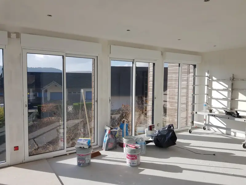 Intérieur lumineux d’une extension à Meursault avec grandes baies vitrées et vue sur le jardin.